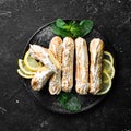 Eclair with lemon cream. Lemon dessert on a black stone plate. Top view. Rustic style Royalty Free Stock Photo