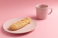 Eclair on the plate. Pink pastel background. Dessert concept, minimalism