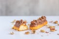Eclair with vanilla cream, peanuts and chocolate. Royalty Free Stock Photo