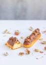 Eclair with vanilla cream, peanuts and chocolate. Royalty Free Stock Photo