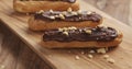 Eclairs with hazelnuts on wood board Royalty Free Stock Photo
