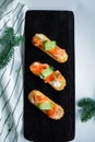 Eclairs with salmon, fresh vegetables and herbs, gourmet snacks.