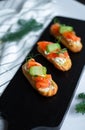 Eclairs with salmon, fresh vegetables and herbs, gourmet snacks.