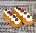 The eclairs with vanilla cream cheese decorated with fressh berries