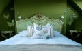 Eclectic bedroom with French Rococo style bed, and walls painted in deep green colour.