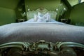 Eclectic bedroom with French Rococo style bed, and walls painted in deep green colour.