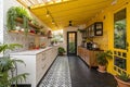 Eclectic kitchen interior with yellow ceiling, black floor and a mix of plants, textures and cheerful tones Royalty Free Stock Photo
