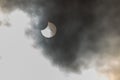Eclipse view through clouds showcasing the moon partially covering the sun Royalty Free Stock Photo