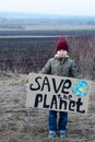 Eco activist boy holding save the planet banner. on the background of arable land. Farmland preservation concept. Royalty Free Stock Photo