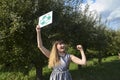 Eco activist young protesting girl hold placard with recycling sign on natural background