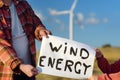 Eco activists with banner `Wind Energy` on background of power stations for renewable electric energy production. Royalty Free Stock Photo