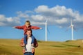 Eco activists man and child on background of power stations for renewable electric energy production. People and windmills. High Royalty Free Stock Photo