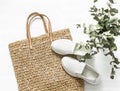 Eco bag made of straw, sport shoes on a white background, top view. Shopping walking concept