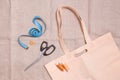 eco bag, scissors, measuring tape and several spools of thread on linen fabric Royalty Free Stock Photo