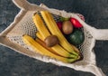 Eco cotton string mesh bag with fruits. Bananas, apples, kiwi, lime and avocado. Ecological Zero Waste Food Shopping