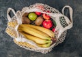 Eco cotton string mesh bag with fruits. Bananas, apples, kiwi, lime and avocado. Ecological Zero Waste Food Shopping