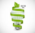 Eco energy concept. Light bulb wrapped with green ribbon and green leaves at the top. Royalty Free Stock Photo