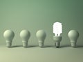 Eco energy saving light bulb, one glowing compact fluorescent lightbulb standing out from unlit incandescent bulbs Royalty Free Stock Photo