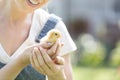 Midsection of mid adult woman holding small chick at farm
