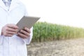 Midsection of mature scientist using digital tablet at farm