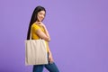 Eco Fashion. Cheerful Asian Girl Holding White Tote Bag Over Purple Background