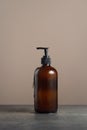 Eco-friendly amber glass soap dispencer with pump bottle filled with dishsoap or body wash on dark marble background