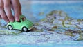 Eco friendly auto model driving across Europe on world map, travel by car Royalty Free Stock Photo