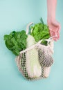 Eco-friendly beige shopping bag with grapes on a white background. String bag with fruits. Zero waste, no plastic concept