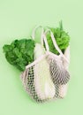 Eco-friendly beige shopping bag with grapes on a white background. String bag with fruits. Zero waste, no plastic concept