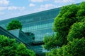 Eco-friendly building in the modern city. Sustainable glass office building with trees for reducing heat and carbon dioxide. Royalty Free Stock Photo