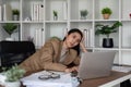 Eco friendly, businesswoman young asian stress in working on laptop while sitting at home office, green room area Royalty Free Stock Photo