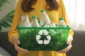 Eco friendly concept woman recycles plastic bottle in home recycling bin