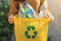 Eco friendly concept woman recycles plastic bottle in home recycling bin