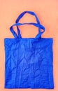 Eco-friendly cotton bag in classic blue color against a peach color background