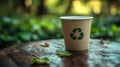 Eco-friendly disposable cup on a wooden table surrounded by greenery Royalty Free Stock Photo