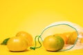 Eco-friendly. Fresh tangerines in reusable eco friendly mesh bag on yellow background. Copy space. Concept of zero waste