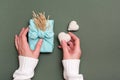 Eco friendly gift for valentine`s day furoshiki and knitted hearts in female hands on a green background Royalty Free Stock Photo