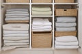 Eco-Friendly Linen Cupboard Organization with Neatly Folded Linens in Straw Baskets.