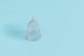 Eco-friendly menstrual cup on light blue background, space for text Royalty Free Stock Photo