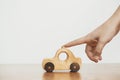 Eco friendly plastic free toy for toddler. Hand playing with natural wooden car toy on table on white wall background. Space for Royalty Free Stock Photo