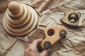 Eco friendly plastic free toys for toddler gift. Hand holding modern natural wooden car toy, pyramid, teether hedgehog on craft Royalty Free Stock Photo