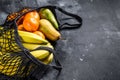 Eco friendly reusable shopping string bag, filled with fruits. Eco friendly, plastic free. Black background. Top view. Copy space Royalty Free Stock Photo