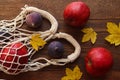 Eco-friendly string bag with apples and figs on a wooden autumn background with maple leaves. Eco shopping, zero waste