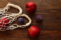 Eco-friendly string bag with apples and figs on a wooden background. Eco shopping, zero waste concept. Mesh bag with