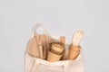 Eco-friendly tableware - kraft paper food cups and containers in cotton bag on gray background with copy space. Street food take Royalty Free Stock Photo