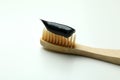 Eco friendly toothbrush with black toothpaste on white background