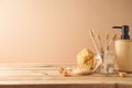 Eco friendly toothbrush and soap dispenser on wooden table over beige background