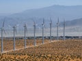 Sustainable Energy Generation. White Wind Turbines in Arid Desert Landscape with Distant Mountains