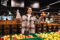 Eco friendly woman buys apples in the supermarket. Female grocery shopper opposes the use of plastic bags. Royalty Free Stock Photo