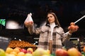 Eco friendly woman buys apples in the supermarket. Female grocery shopper opposes the use of plastic bags. Royalty Free Stock Photo